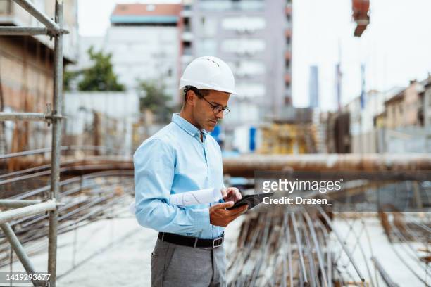 bauarbeiter oder ingenieur mit digitalem tablet - under construction stock-fotos und bilder