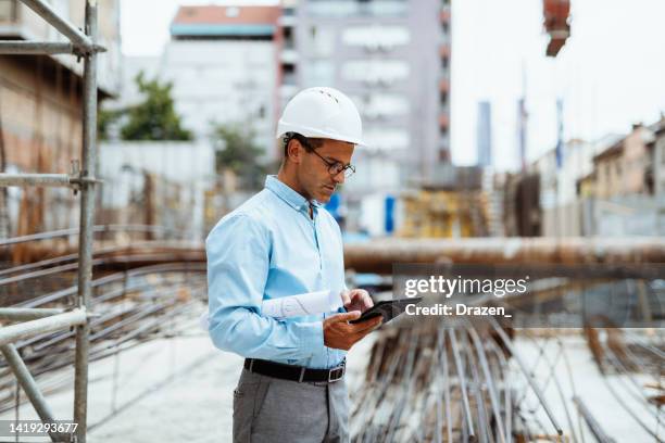 construction worker or engineer using digital tablet - engenheiro imagens e fotografias de stock