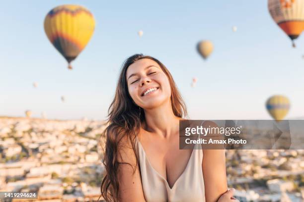 young woman feels happy and smiling on hot air balloons cappadocia background - cappadocia hot air balloon 個照片及圖片檔