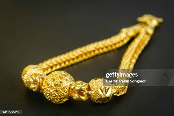 gold necklaces and gold jewelry on a black background. - gold medal stock pictures, royalty-free photos & images