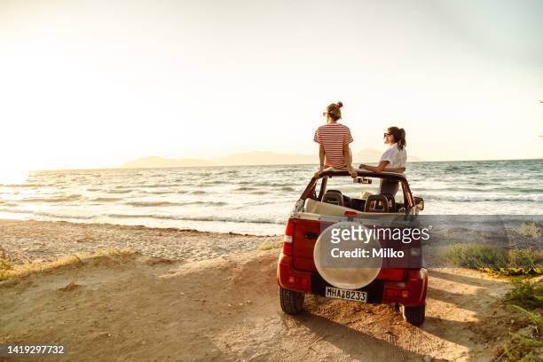 two young women enjoy the view of the sea and the sunset - car back view bildbanksfoton och bilder