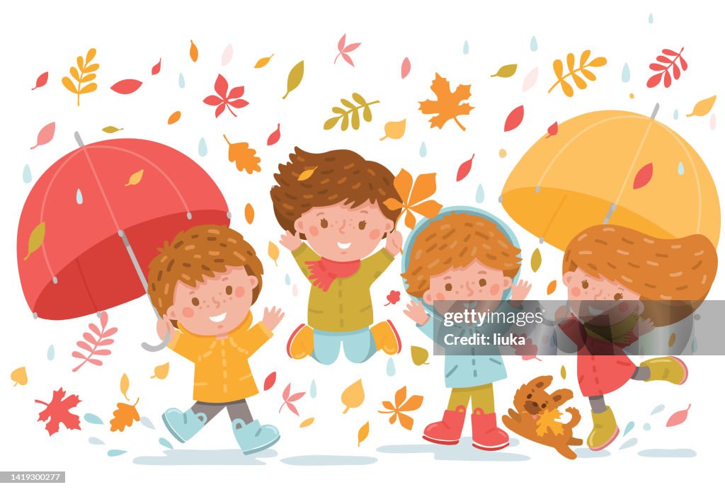 Group of kids playing and jumping in the falling autumn leaves