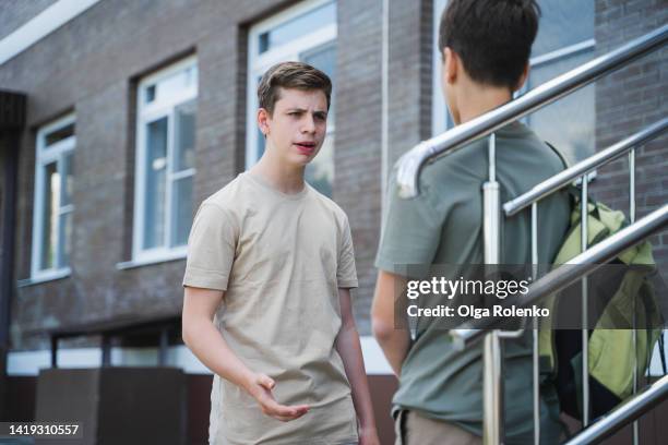 high school student yelling at middle school student in the backyard of the school - peer pressure stock pictures, royalty-free photos & images