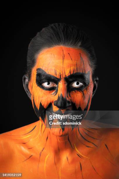 smiling woman in creepy pumpkin face paint - scary pumpkin faces bildbanksfoton och bilder