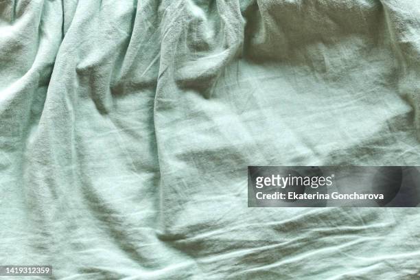 green fabric with pleats. abstract textile background - sábana ropa de cama fotografías e imágenes de stock