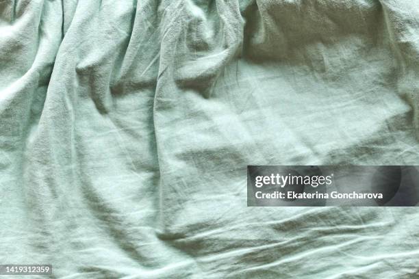 green fabric with pleats. abstract textile background - bedsheets stockfoto's en -beelden