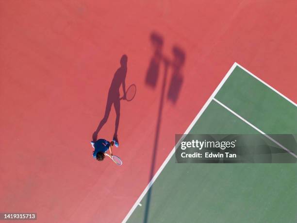 directly below drone point of view asian chinese tennis player practising in tennis court in the morning - young tennis player stock pictures, royalty-free photos & images