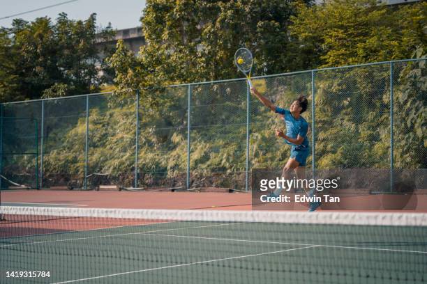 asian chinese male professional tennis player jumping mid air serving in hardcourt - hardcourt 個照片及圖片檔