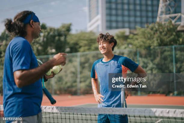 jeune joueur de tennis chinois d’origine asiatique écoutant l’entraîneur pendant l’entraînement de routine le matin - tennis coaching photos et images de collection