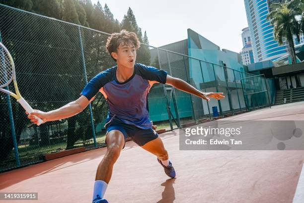 aggressive asian chinese male tennis player aiming to hit tennis ball in hardcourt tennis competition - forehand stockfoto's en -beelden