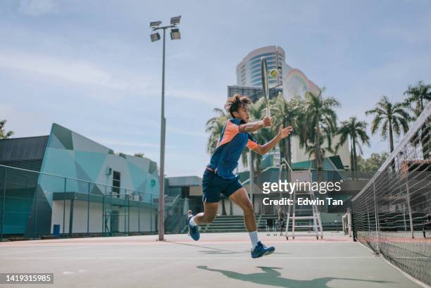 skilful asian chinese tennis player jumping mid air making a save - hardcourt stock pictures, royalty-free photos & images