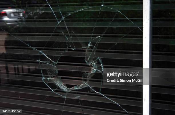 broken shopfront window and metal security shutter - roubando crime - fotografias e filmes do acervo