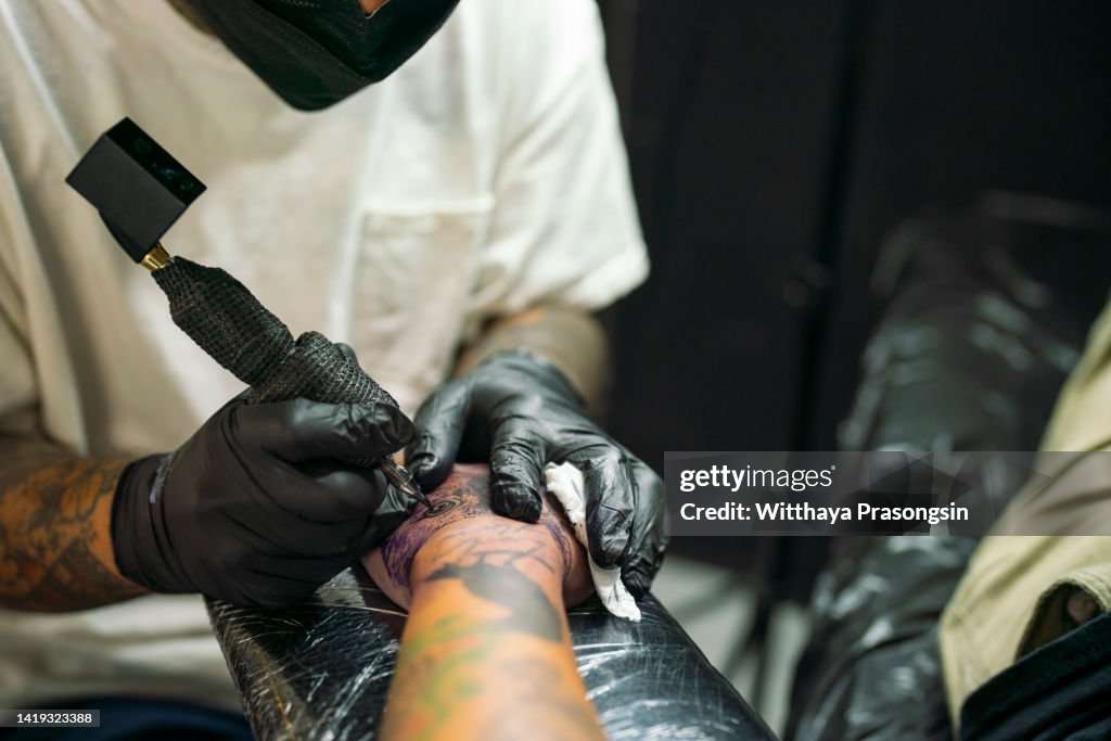 Tattooist demonstrate the process tattoo on hand