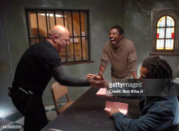 Michael Chilkis playfully arm-wrestles with co-star Greg Eagles while Director Vondi Curtis-Hall watches the action on the set of FX series The...