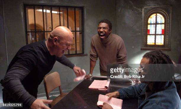 Michael Chilkis playfully arm-wrestles with co-star Greg Eagles while Director Vondi Curtis-Hall watches the action on the set of FX series The...