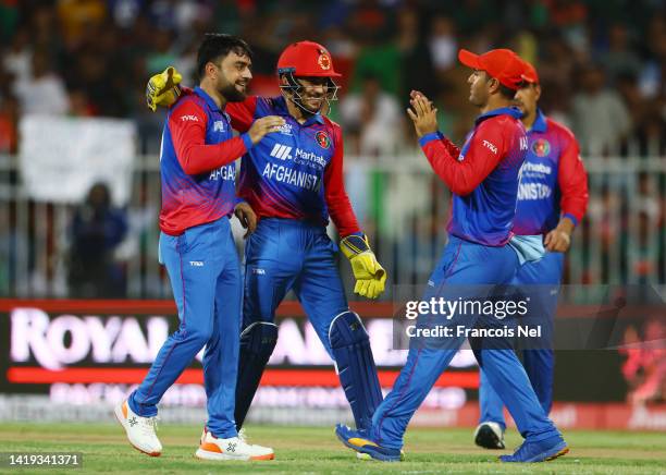 Rashid Khan of Afghanistan celebrates with team mates during the DP World T20 match between Bangladesh v Afghanistan at Sharjah Cricket Stadium on...