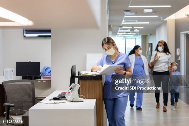 doctor walks patient to their room - posto de enfermagem imagens e fotografias de stock