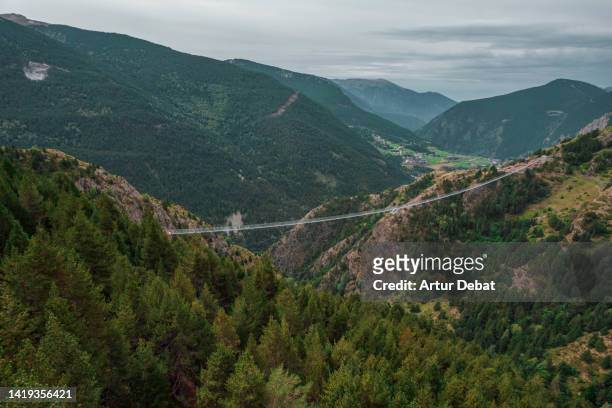 aerial view of a pedestrian suspended bridge crossing valley in the andorra pyrenees. - sunday in the valley fotografías e imágenes de stock