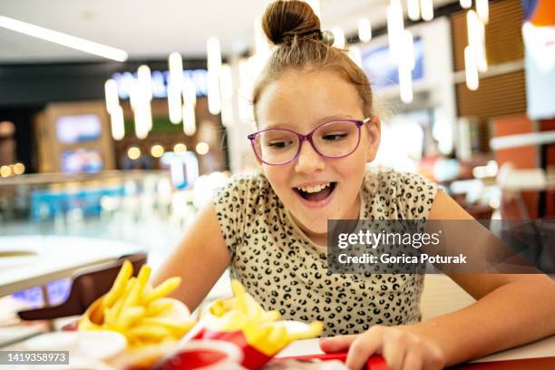teenage girl enjoying in fast food - girl eating burger stock pictures, royalty-free photos & images