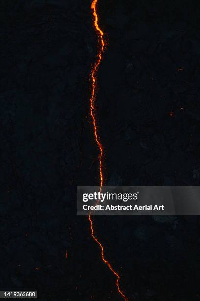 single stream of lava shot from directly above by drone, iceland - burning photograph stock pictures, royalty-free photos & images