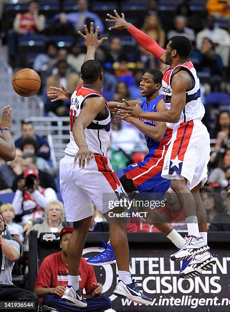 Detroit Pistons point guard Brandon Knight , center, dishes off the ball around Washington Wizards forward Kevin Seraphin , left, and Wizards point...