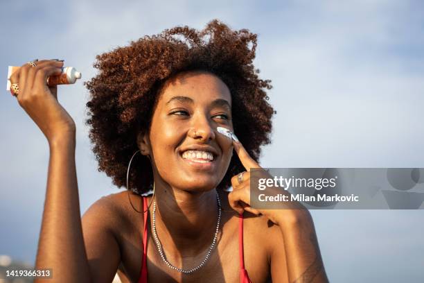 protejo mi piel con protector solar - untar fotografías e imágenes de stock