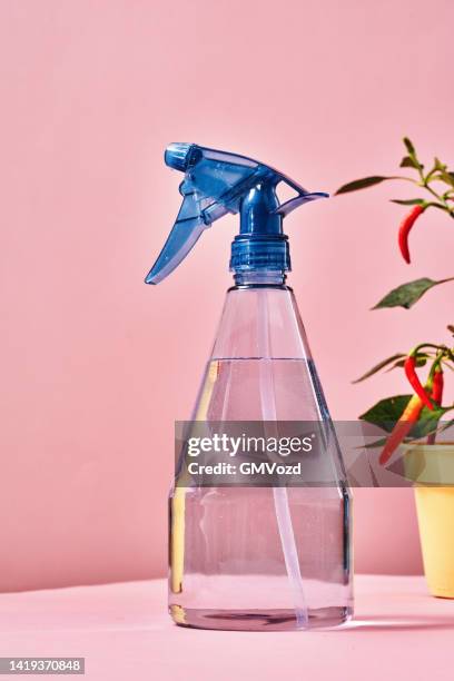 plastik-wassersprühflasche auf lebendigem hintergrund - spray bottle stock-fotos und bilder