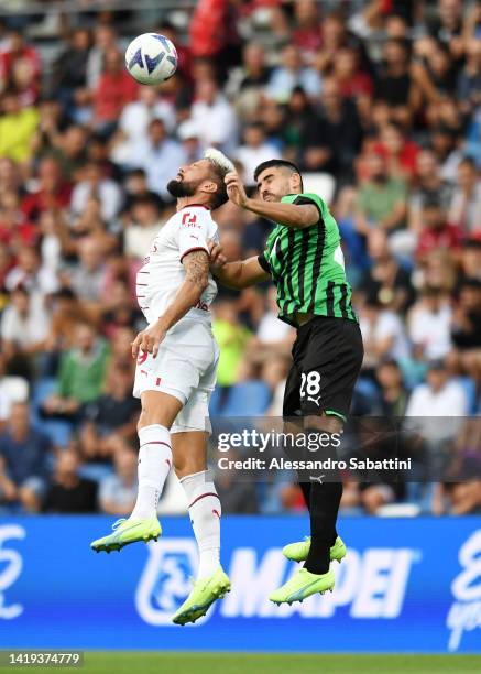 Olivier Giroud of AC Milan jumps for the ball with Martin Erlic of US Sassuolo during the Serie A match between US Sassuolo and AC MIlan at Mapei...