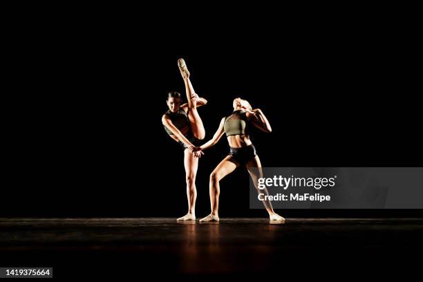 duetto di ragazza che esegue la danza contemporanea sul palcoscenico scuro - contemporary dance foto e immagini stock