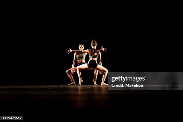 girl duet performing contemporary dance on dark stage - duett bildbanksfoton och bilder