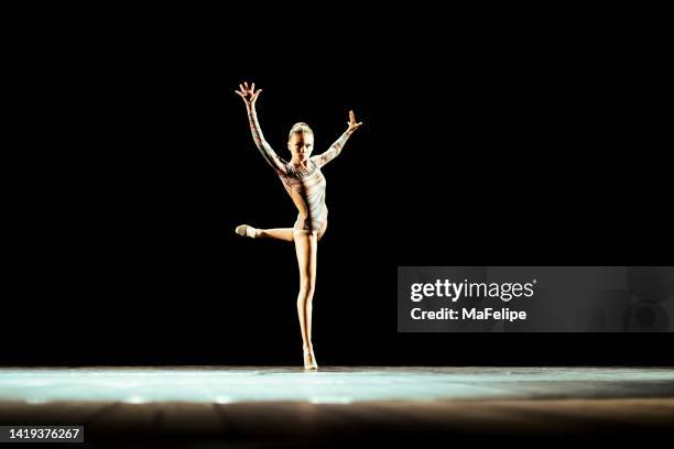 girl performing contemporary dance on dark stage - dance competition stock pictures, royalty-free photos & images