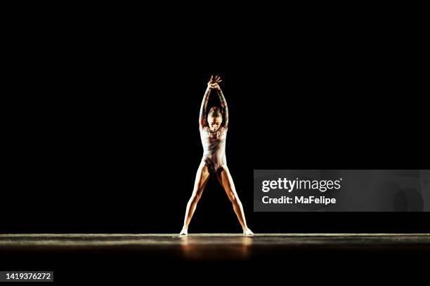 girl performing contemporary dance on dark stage - dance contest stock pictures, royalty-free photos & images