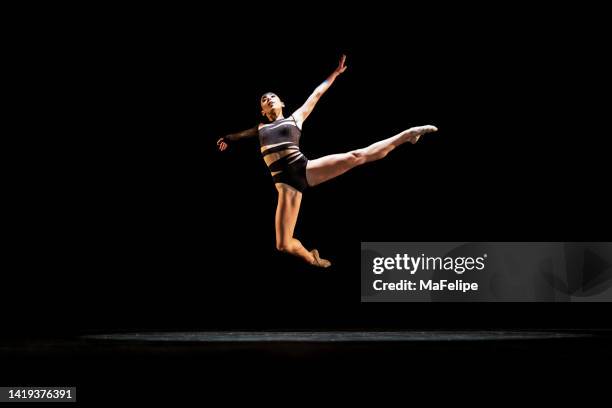 girl performing contemporary dance on dark stage - contemporary dance stock pictures, royalty-free photos & images