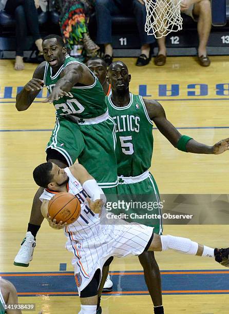 Boston Celtics' Brandon Bass blocks Charlotte Bobcats' DJ Augustin's shot during Monday night's game on March 26 at Time Warner Cable Arena in...