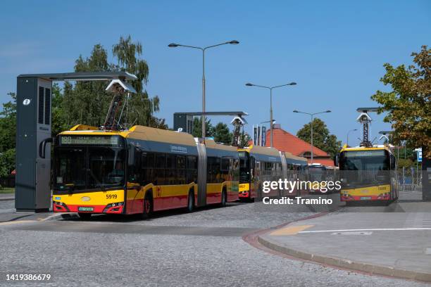 electric buses on a charging points - warsaw bus stock pictures, royalty-free photos & images