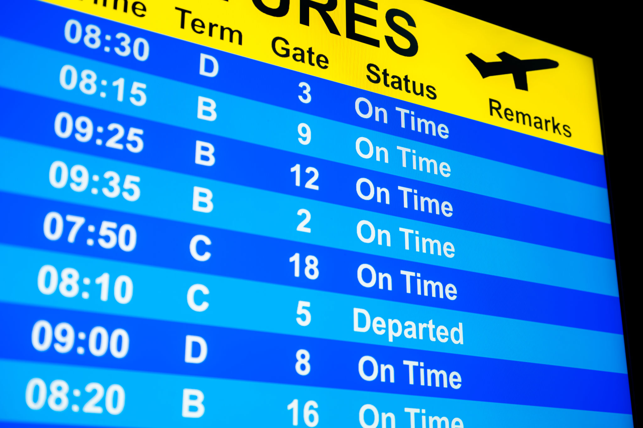 Close-up of a Departure Board with all flights “On-Time” or “Departed”. Close-up of a Departure Board with all flights “On-Time” or “Departed”.