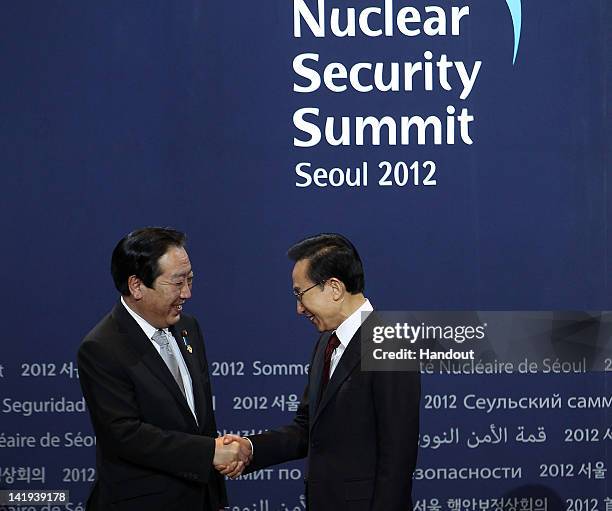 In this handout image provided by Yonhap News, Japanese Prime Minister Yoshihiko Noda and South Korean President Lee Myung-bak shake hands prior to...