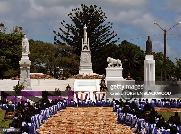 School children bow their heads in respect along a road paved with tapa cloth after the arrival of the late King George Tupou V at the Mala'ekula...