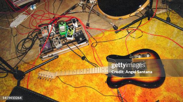 guitar, drum and music equipment on floor in a rehearsal room - guitar amp stock-fotos und bilder