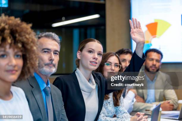 businesswoman raising her hand. - hands raised business stock pictures, royalty-free photos & images