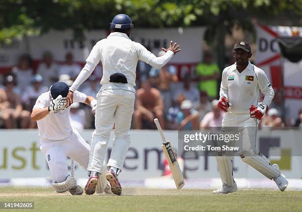 Jonathan Trott of England falls to the ground after colliding with the keeper Prasanna Jayawardene of Sri Lanka after being stumped during day 2 of...