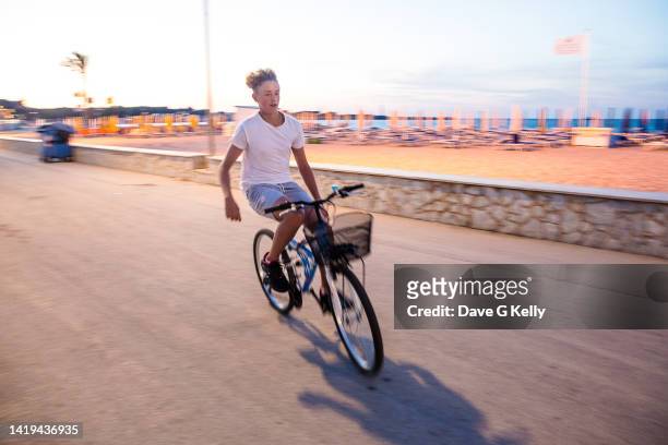 motion blur of teenage boy on a bicycle - freihändiges fahrradfahren stock-fotos und bilder