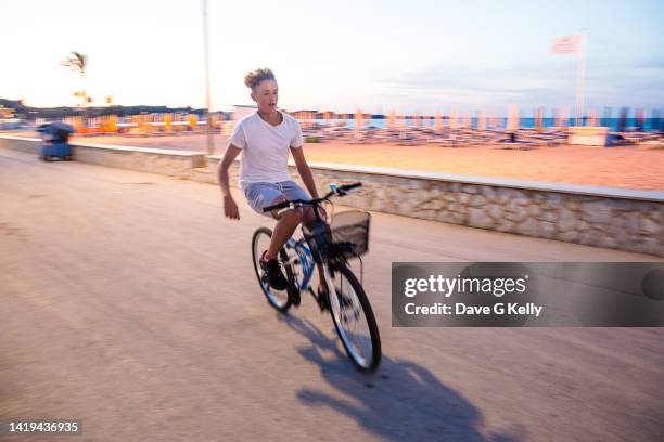 motion blur of teenage boy on a bicycle - hands free cycling - fotografias e filmes do acervo