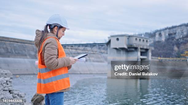 female engineer working in hydroelectric dam. ecology orientated. renewable energy systems. - hydroelectric power station stock pictures, royalty-free photos & images