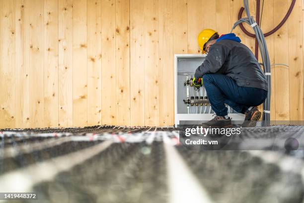 plumber mounting underfloor heating manifold - rörmokare bildbanksfoton och bilder