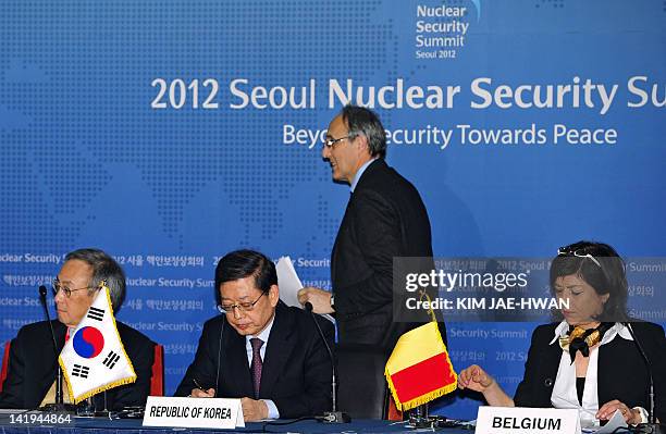 French Atomic Energy Commission chairman Bernard Bigot walks past South Korean Prime Minister Kim Hwang-Sik , Belgium Deputy Prime Minister Joelle...