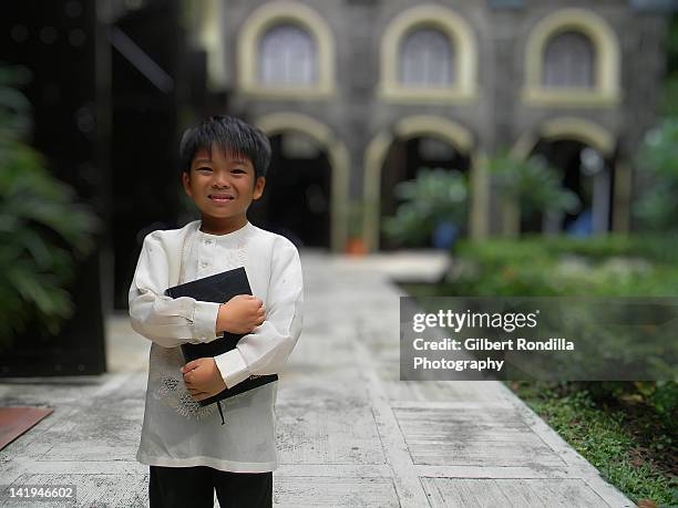 smiling boy holding bible - barong dance stock pictures, royalty-free photos & images