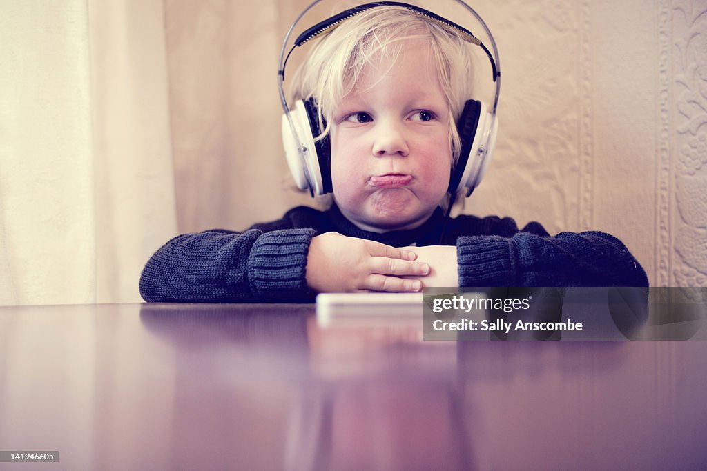 Child with sad face and headphones on