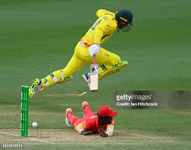 Alex Carey of Australia jumps over Wesley Madhevere of Zimbabwe as he attempts a run out during game two of the One Day International series between...