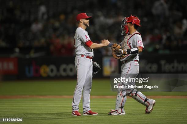 Ryan Tepera and Kurt Suzuki of the Los Angeles Angels celebrate on the field during the game against the Oakland Athletics at RingCentral Coliseum on...